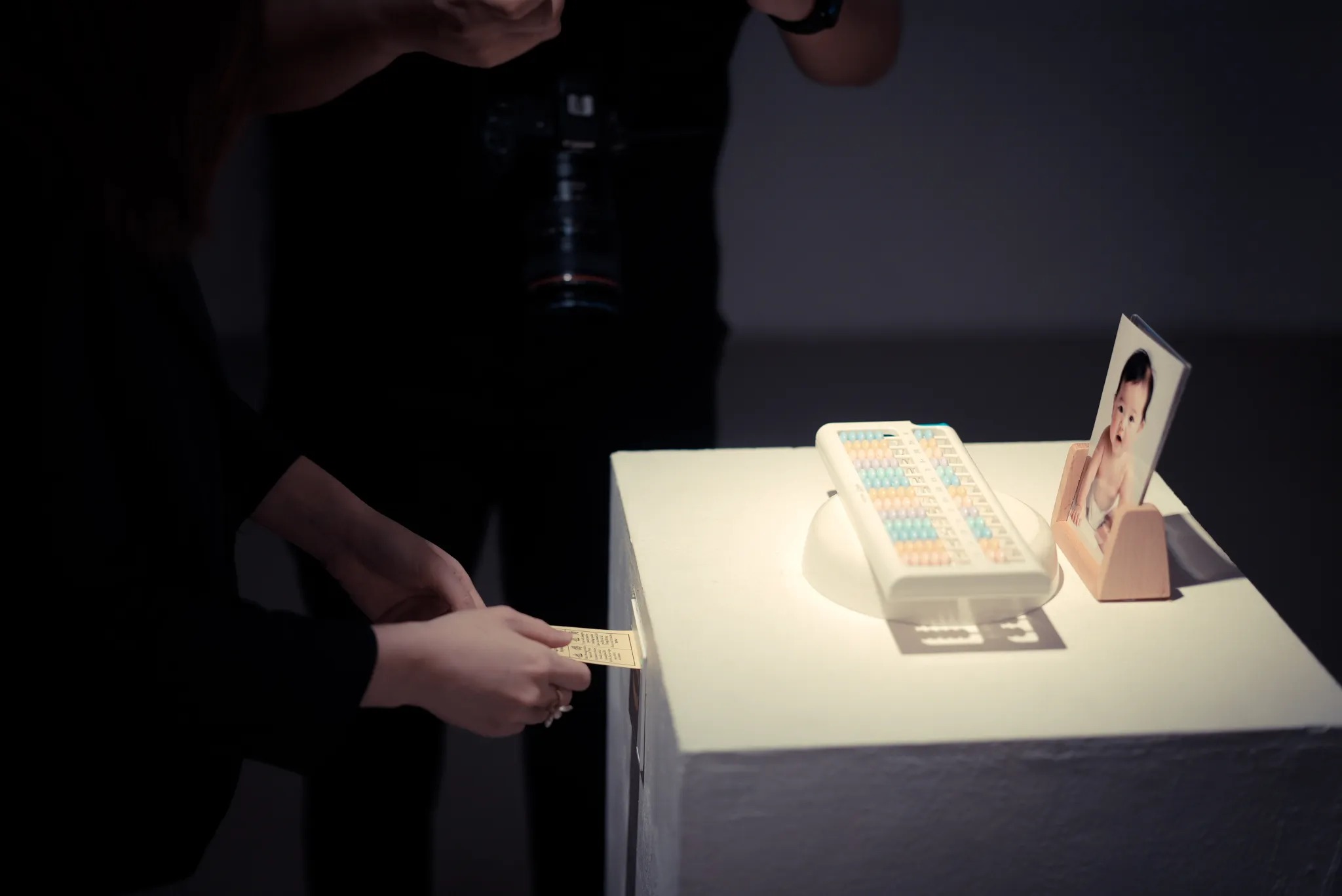 Visitor collecting a fortune beside a baby photograph and toy abacus