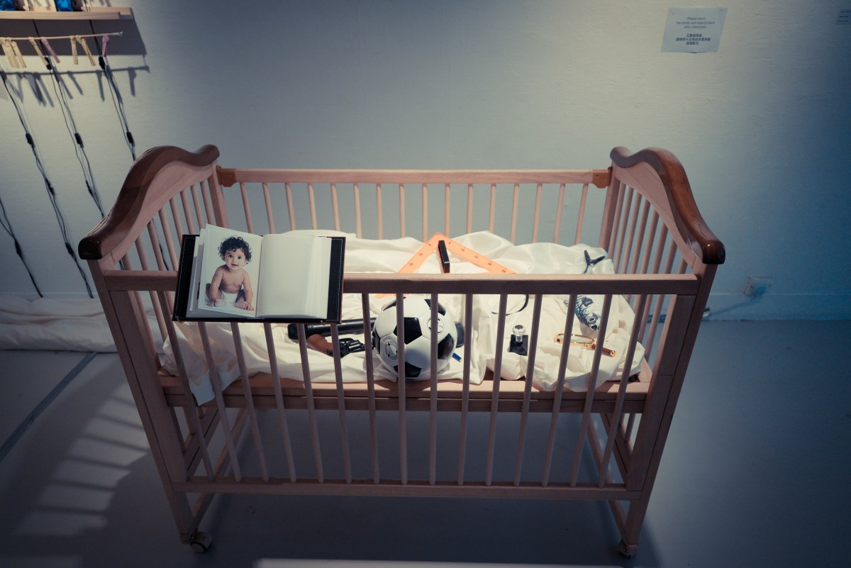 Cradle containing toys and an album of baby photographs